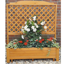 Houten bloembak met klimrek en beplanting voor een bakstenen muur