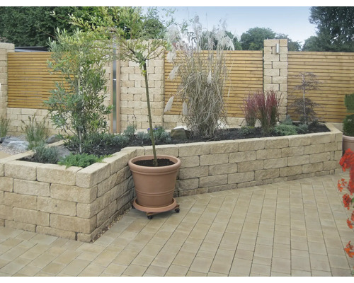 Ontwerpidee voor een tuin met verhoogde plantenbak en houten schutting