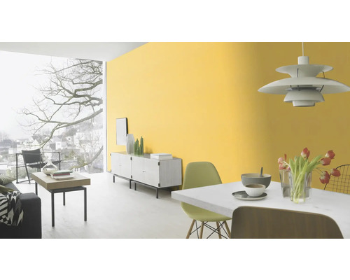 Lichte woonkamer met gele muurverf, eettafel, dressoir en raampartij