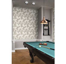 Een kamer met een patroonbehang, een biljarttafel en een hanglamp.