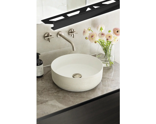 Moderne badkamer met opzetwastafel, kraan, bloemen en ledprofiel