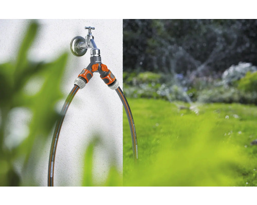 Waterkraan met tweewegverdeler en aangesloten tuinslangen voor tuinbesproeiing
