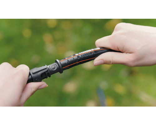 Een persoon verbindt een tuinslangstuk met een tuinslang.