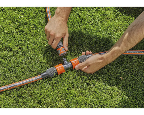 Tuinbewateringsscène met T-stuk en slangaansluitingen op gazon