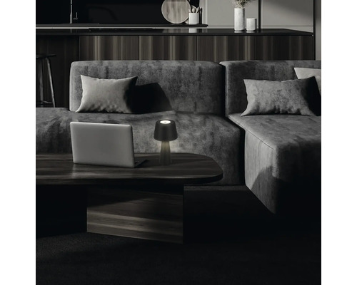 Woonkamer scène met bank, tafellamp en laptop op een salontafel