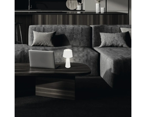 Scene met laptop en tafellamp op een salontafel voor een bank