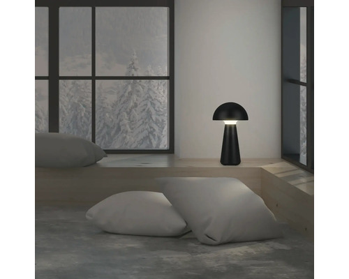 Decoratieve LED-tafellamp in een kamer met kussens en raam