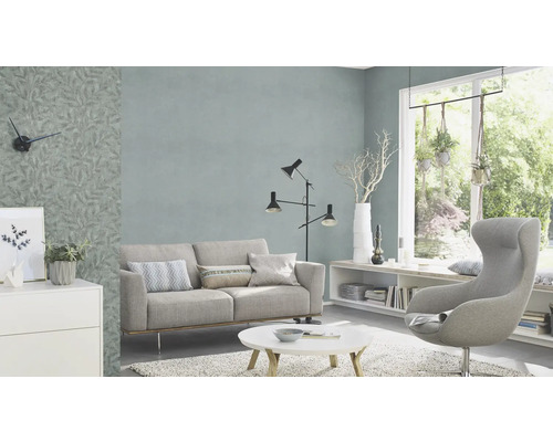 Woonkamer met bank, fauteuil, staande lamp en behang