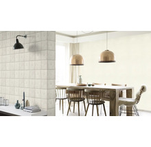 Lichte eetkamer met houten tafel, stoelen, hanglampen en een muur met steenlook behang.