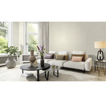 Woonkamer met bank, salontafel en behang met bladerpatroon