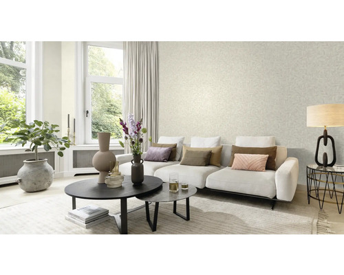 Woonkamer met bank, salontafel en behang met bladerpatroon