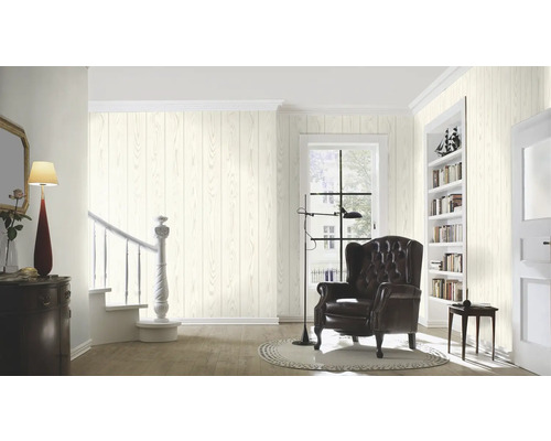 Woonkamer met houten behang, fauteuil en trap