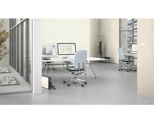 Kantoor met bureaus, bureaustoelen en computers in een moderne werkruimte.