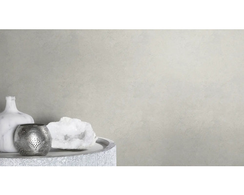 Decoratieve scène met vaas, theelichthouder en siersteen op een tafel voor een lichte wand