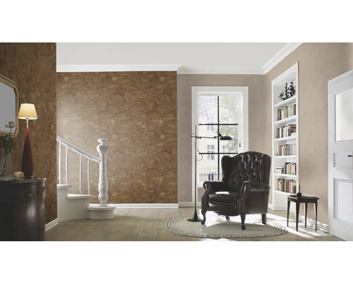 Woonkamer met bruin behang, fauteuil en boekenkast