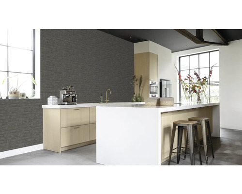 Lichte keuken met grijze bakstenen behang, kookeiland en barkrukken.