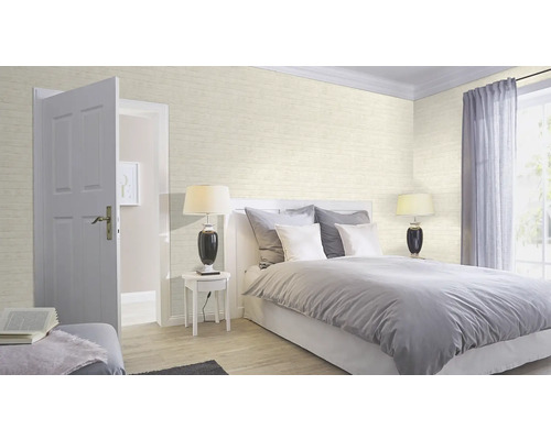 Lichte slaapkamer met bed, nachtkastje, lamp en behang in baksteenmotief