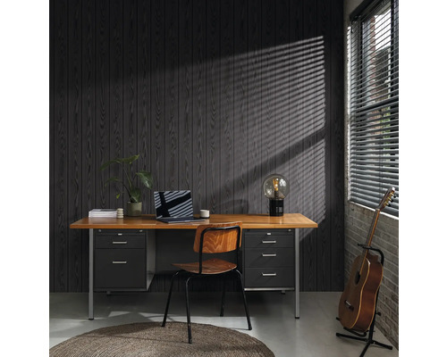 Kantoor met bureau, stoel, lamp, gitaar en laptop voor een donkere houten lambrisering