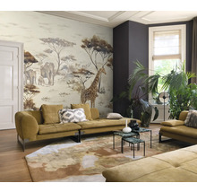 Woonkamer met muurschildering, banken, salontafels, vloerkleed en kamerplanten