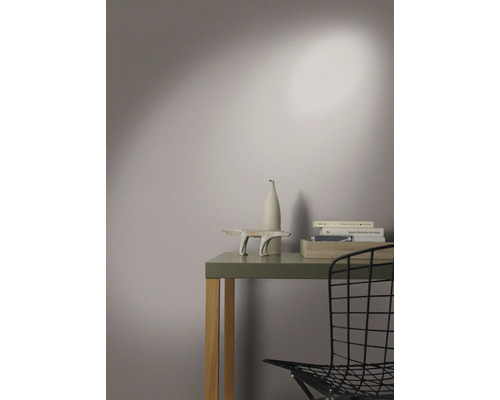 Decoratieve opstelling op een tafel met een sculptuur, vaas en boeken in een lichte kamer