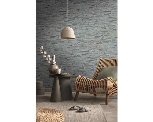 Decoratieve woonkamer met rotan stoel, steenbehang, bijzettafel, lamp en vloerkleed voor een gezellige sfeer