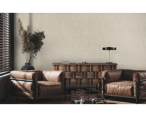 Woonkamer met beige vliesbehang met linnenstructuur, twee lederen fauteuils en houten commode