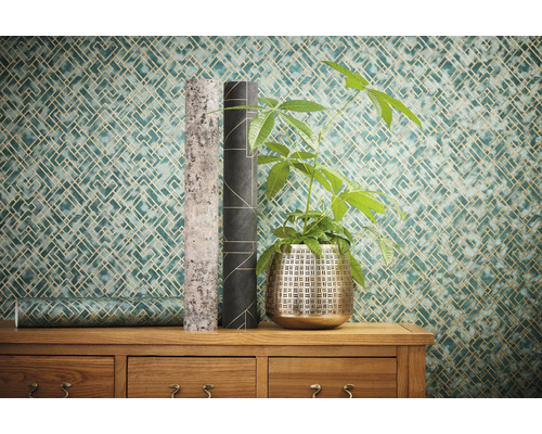 Decoratieve kamer met geometrisch behang, plant en twee rollen behang op een houten kast