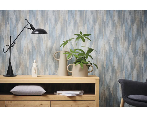 Decoratief interieur met patroonbehang, staande lamp, houten dressoir en kamerplant.