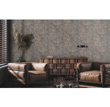 Woonkamer met bruine lederen fauteuils, houten commode en decoratief behang