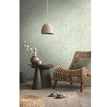 Woonkamer met patroonbehang, rotan stoel en bijzettafel met decoratie