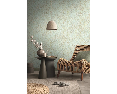 Woonkamer met patroonbehang, rotan stoel en bijzettafel met decoratie