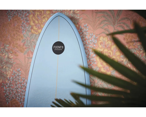 Surfplank tegen een muur met bloemdecoratie