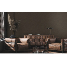 Woonkamer met twee leren fauteuils, houten dressoir en decoratieve elementen.
