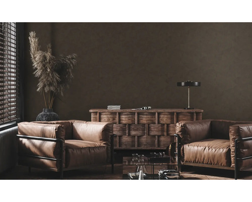 Woonkamer met twee leren fauteuils, houten dressoir en decoratieve elementen.