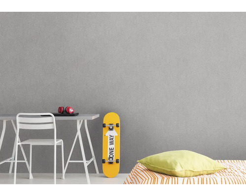 Grijze wanddecoratie in tienerkamer met bureau, stoel en skateboard