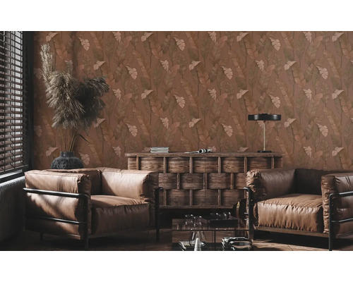 Woonkamer met behang met bladmotief, leren fauteuils en houten meubels