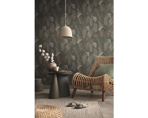 Decoratief interieur met behang met bladerpatroon, rotan stoel en bijzettafel