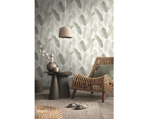 Woonkamer met bladerbehang, rotan stoel en bijzettafel