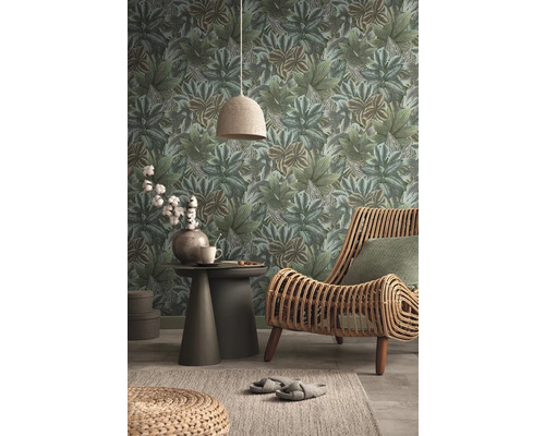 Woonkamer met behang met bladeren, rotan stoel en bijzettafel