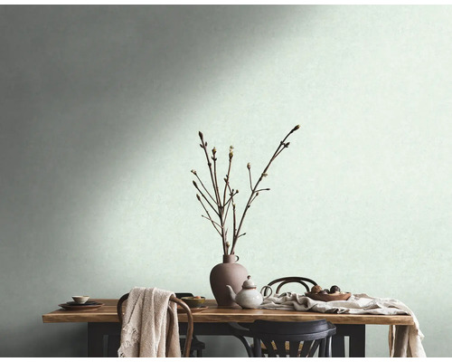Uitnodigende scène met een gedekte houten tafel, servies, een vaas met takken en een lichte muur op de achtergrond