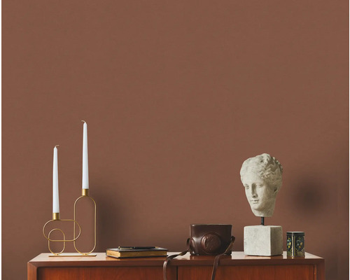 Decoratieve opstelling met kaarsen, buste en camera op een dressoir