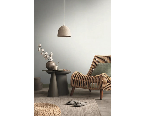 Woonkamer met rotan stoel, bijzettafel, hanglamp en vloerkleed voor een gezellige sfeer