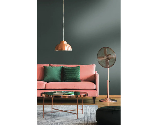 Woonkamer met bank, kussens, tafel, staande ventilator en hanglamp