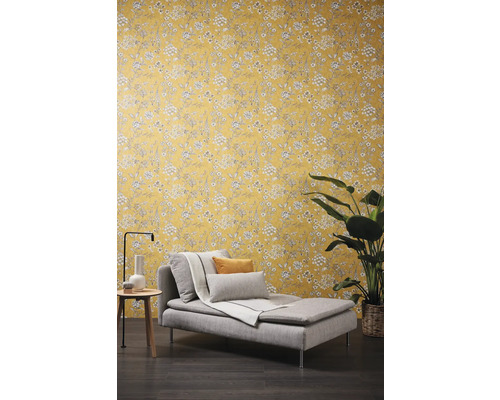 Scene met een ligstoel, een bijzettafel en een bloemmotief behang