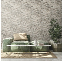 Woonkamer met stenen muur, bank, tafel en plant in pot