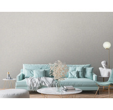 Woonkamer met textielbehang, bank, tafel en decoraties voor een lichte en vriendelijke sfeer.