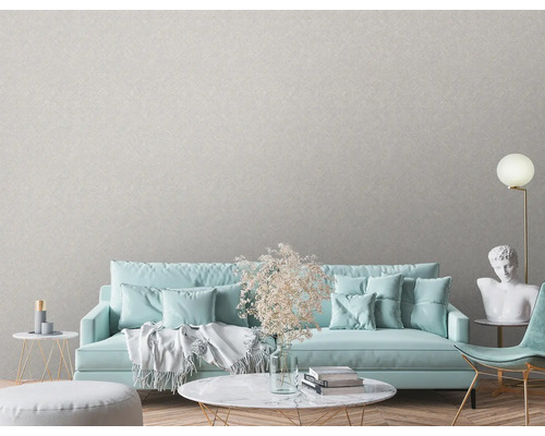 Woonkamer met textielbehang, bank, tafel en decoraties voor een lichte en vriendelijke sfeer.