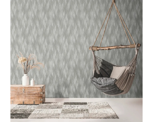 Woonkamer met patroonbehang, hangstoel en houten elementen voor een gezellige sfeer