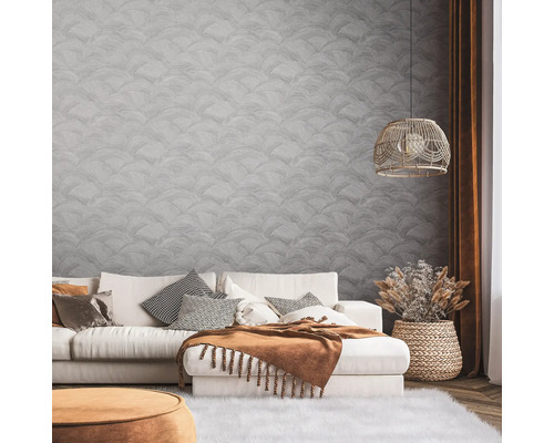 Woonkamer met bank, kussens, deken, lamp en decoratieve wandbekleding voor een stijlvolle sfeer.