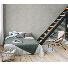 Slaapkamer met bed, ladder, fauteuil en wasmand op houten vloer